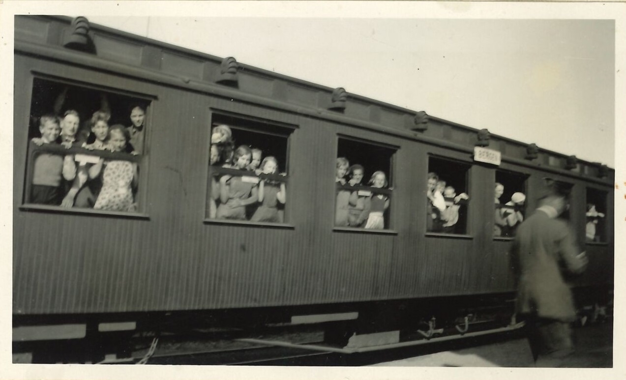 Elever som ser ut fra vinduer om bord i en togvogn på Finse stasjon i 1934