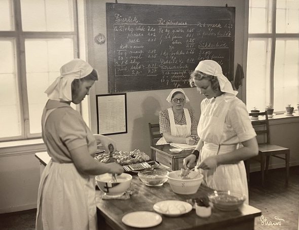 Elever ved Kongsberg husmorskole lager mat. Skolestart - skolebilder i arkivene