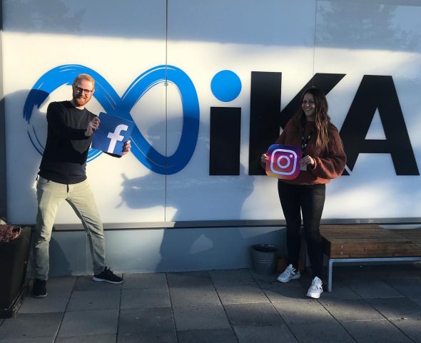 Mann holder Facebook-logo, og kvinne holder Instagram-logo. De står foran en vegg med IKA-Kongsberg-logo.